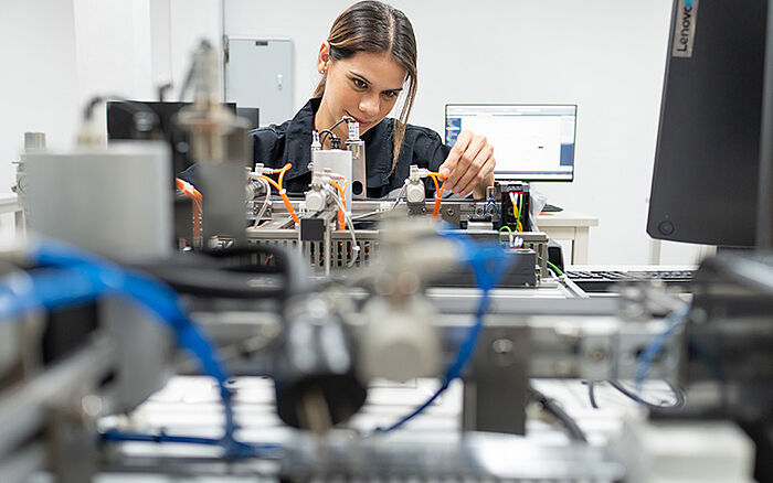 Engineer connecting and controlling a robotic arm in a futuristic, high-tech lab focused on industry 4.0 automation.